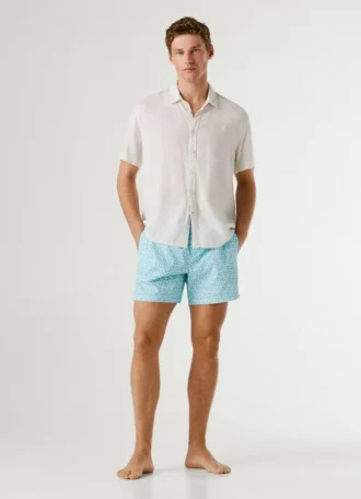 Badshorts med monogram över hela plagget