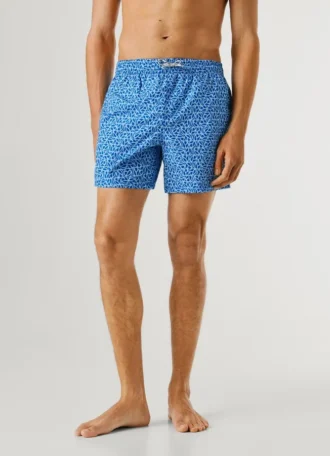 Badshorts med monogram över hela plagget
