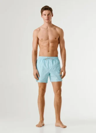 Badshorts med monogram över hela plagget